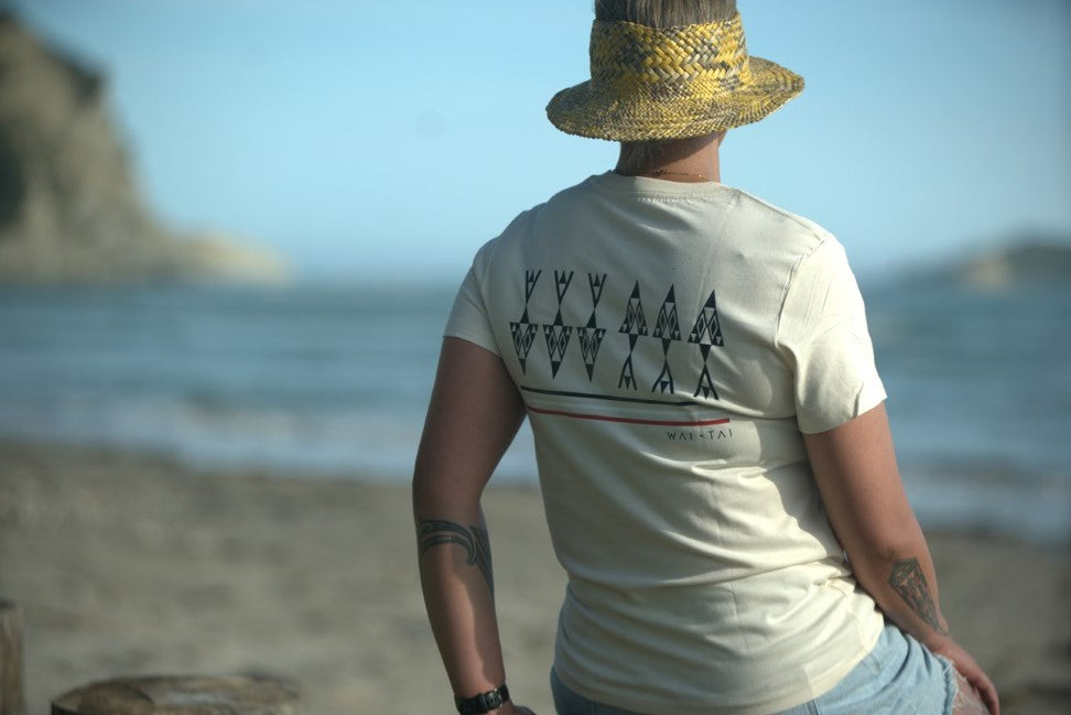 Wai-Tai Womens Ika Tee in ecru colour from rear on model at Kaiti Beach in Gisborne